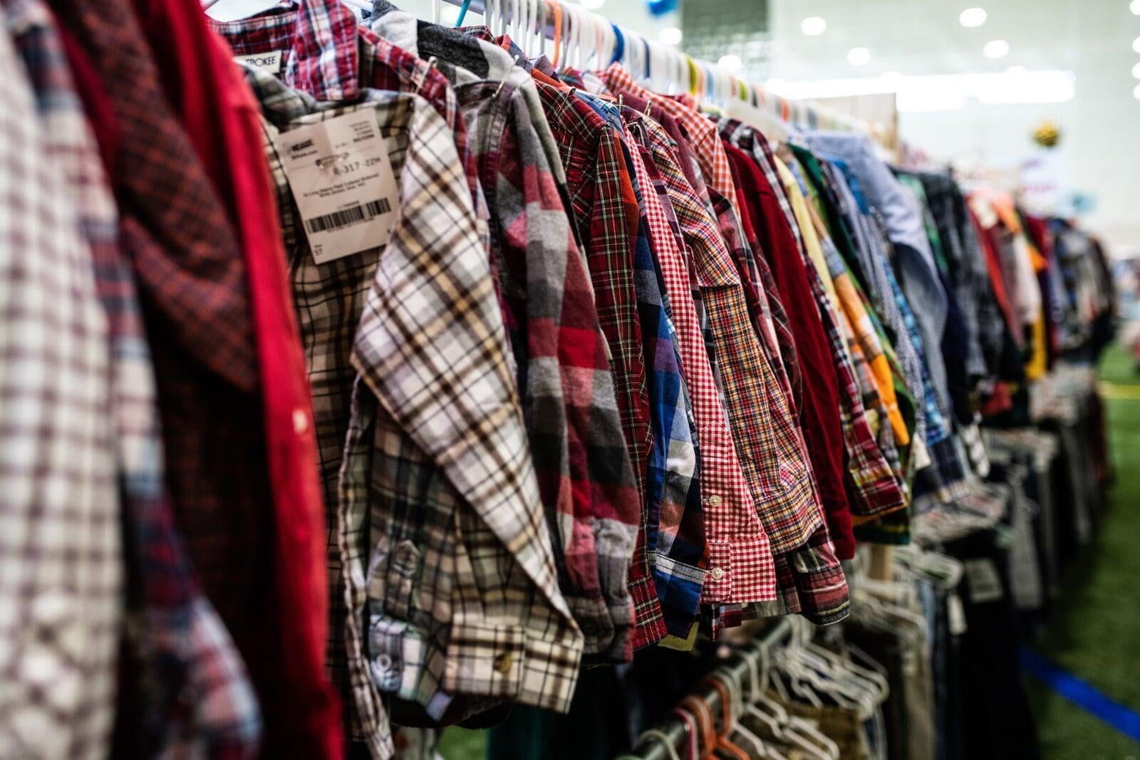 Flannel and plaid long sleeved shirts hanging on clothing racks