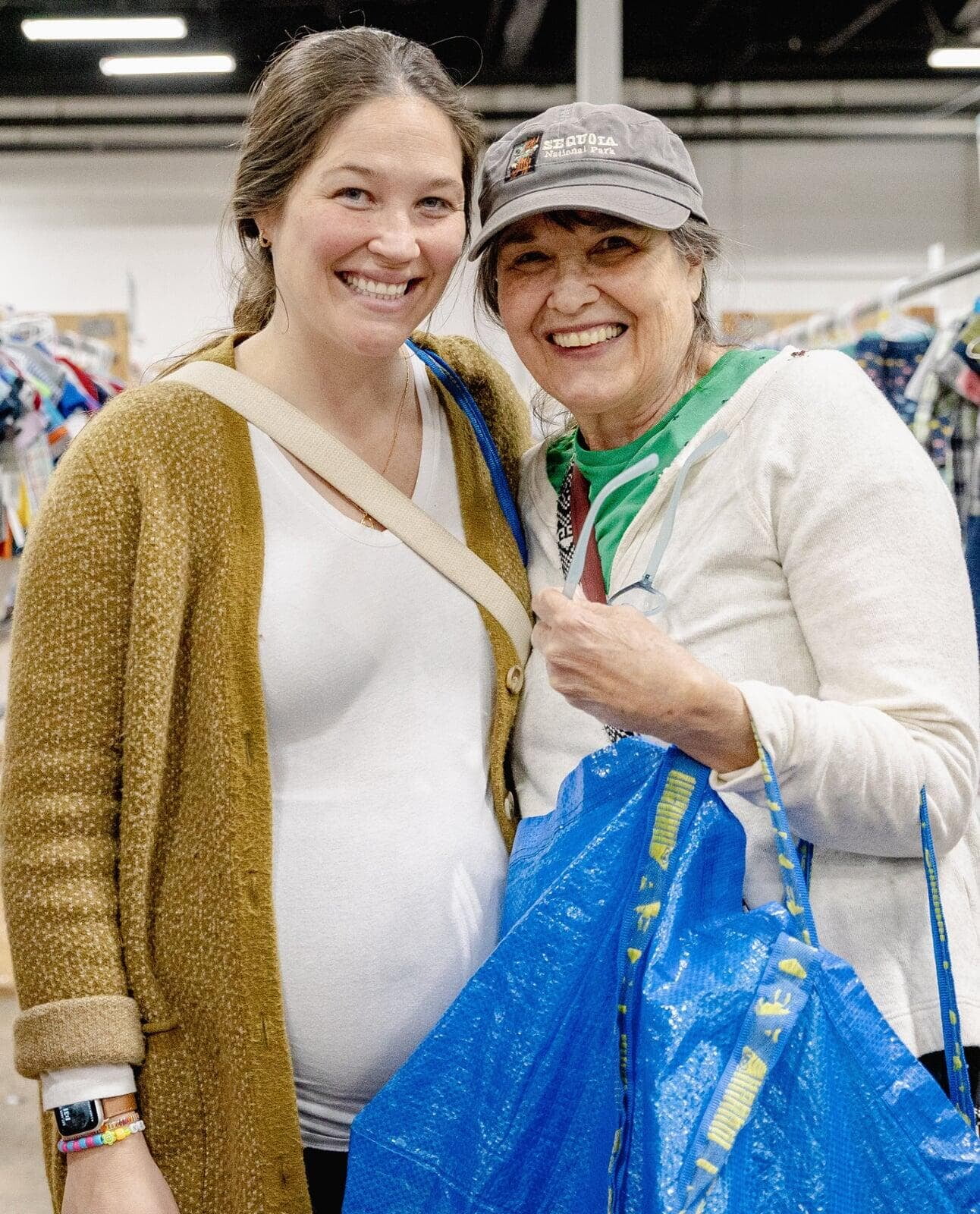 Two women hold up items they found at the JBF sale