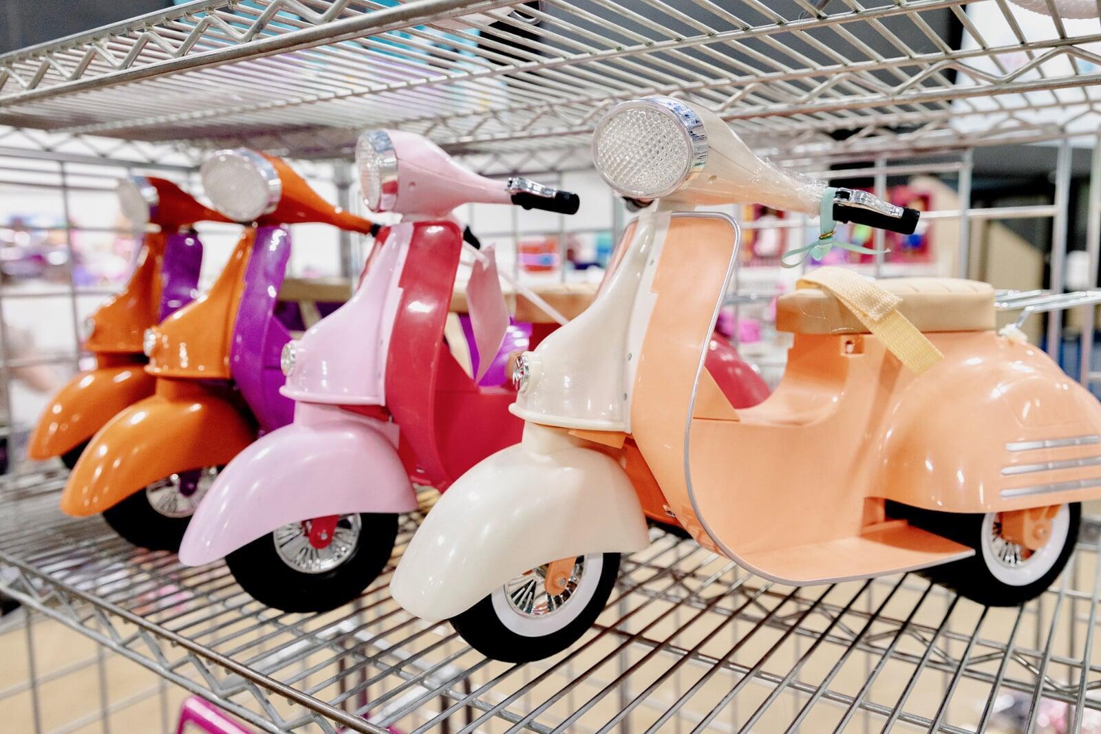 Two women shopping in the girls clothing section. One is holding a baby in a front-carrier.