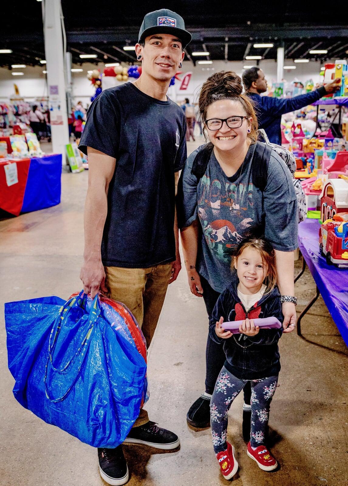 Mom and Dad shopping in the toy aisles with their daughter.