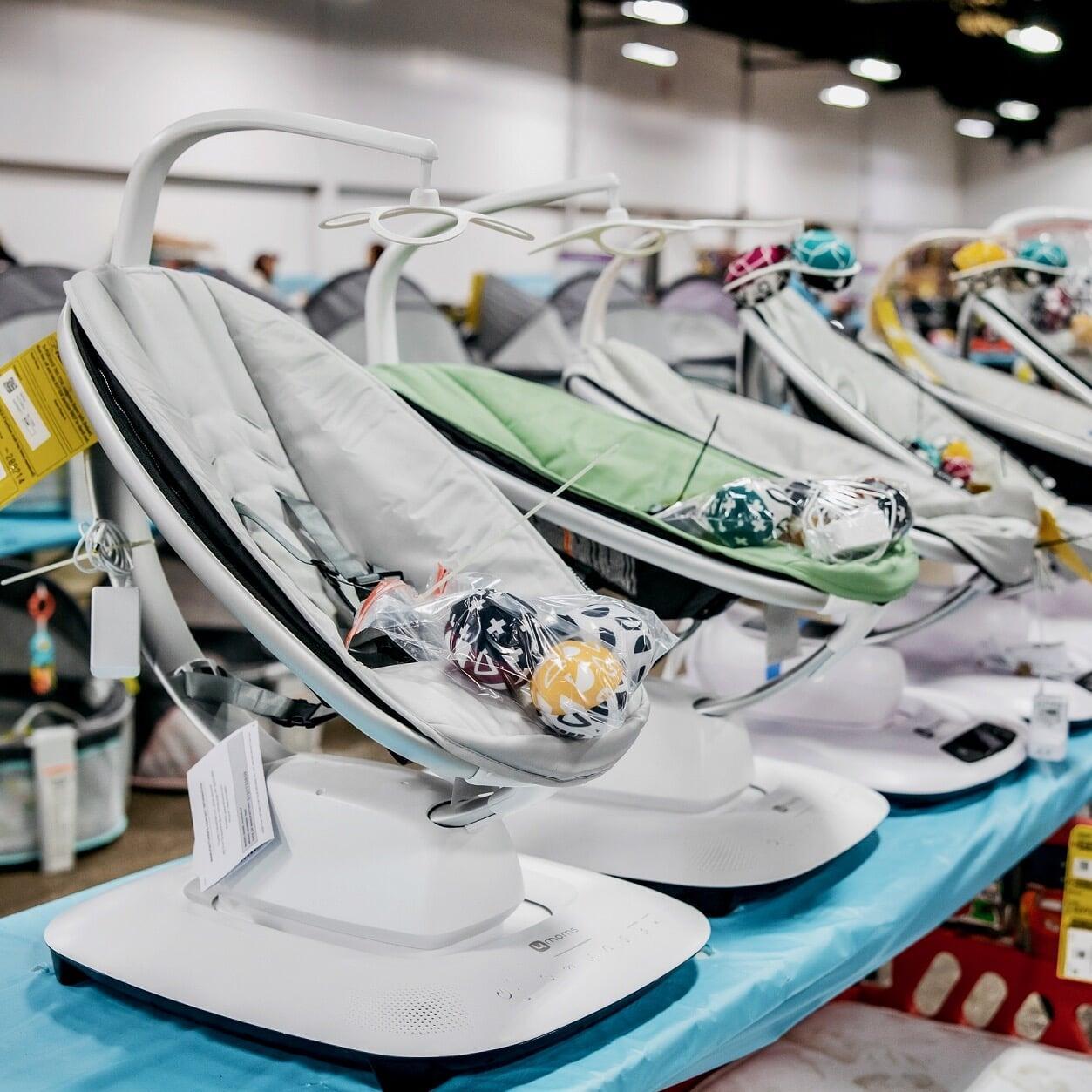 Several infant car seats lined up on a table for sale at the JBF sale.
