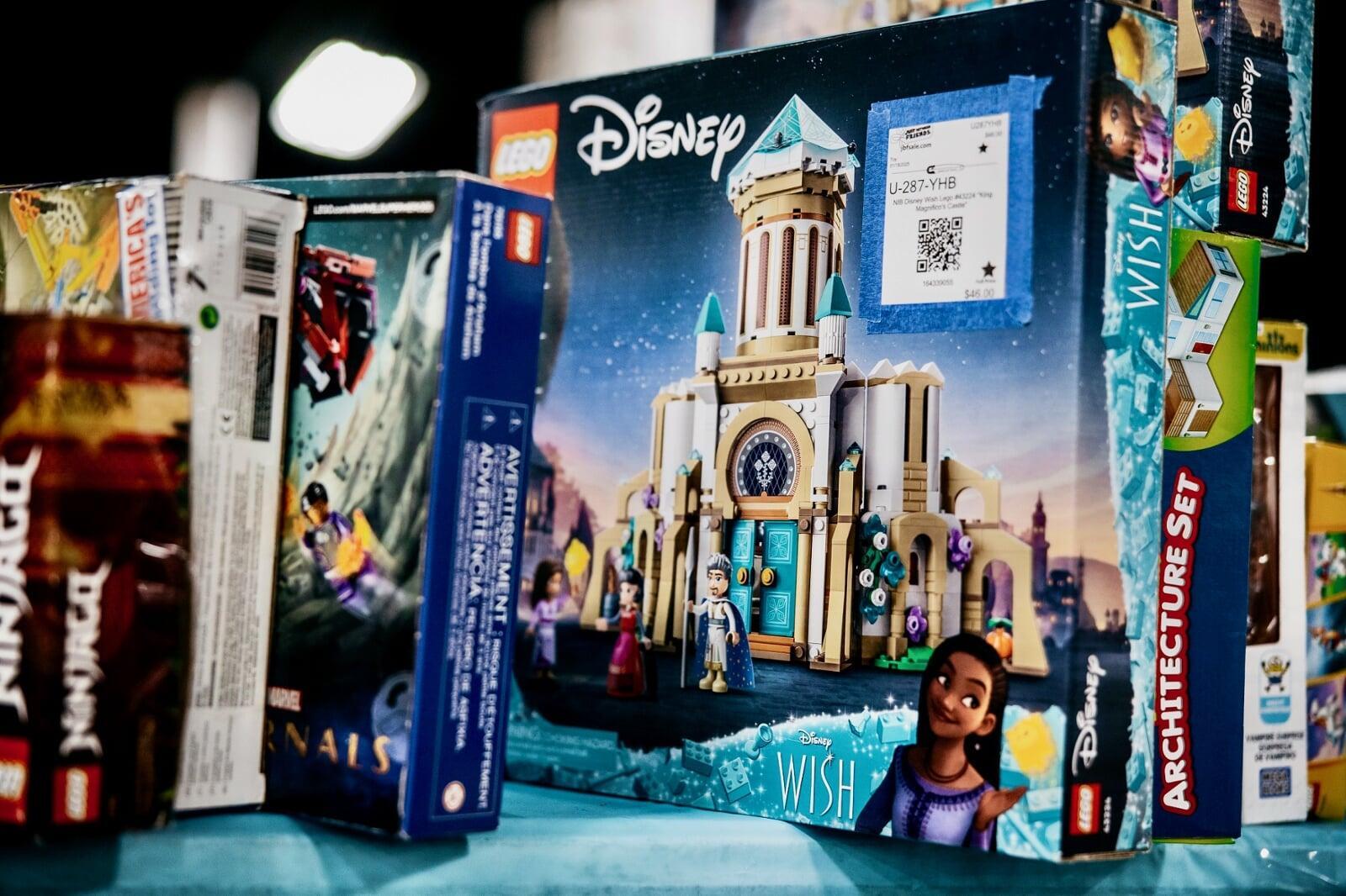 Mother and her two daughters are shopping together. They are standing in between aisles of hanging clothing.