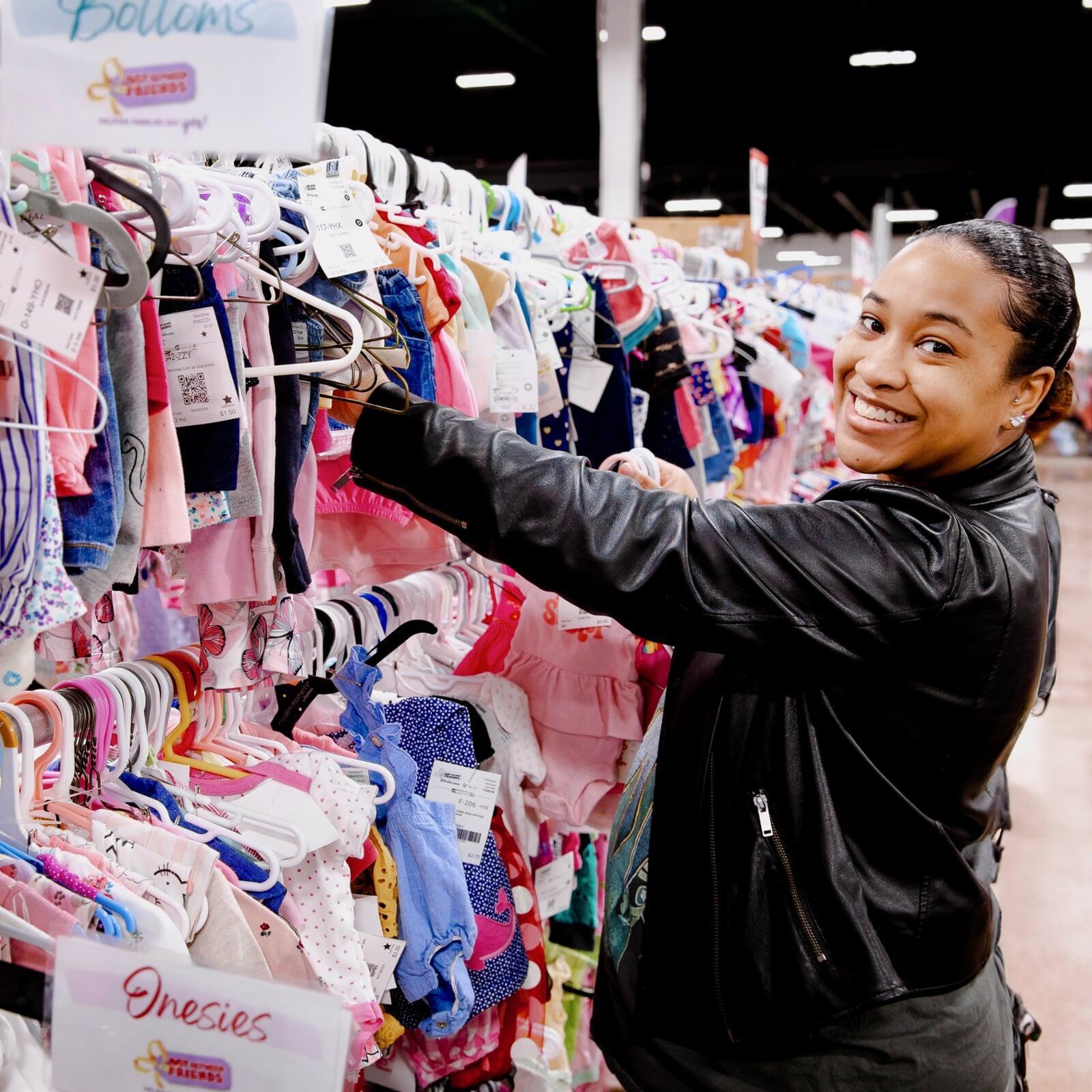 Woman looking through a rack of girl's clothing.