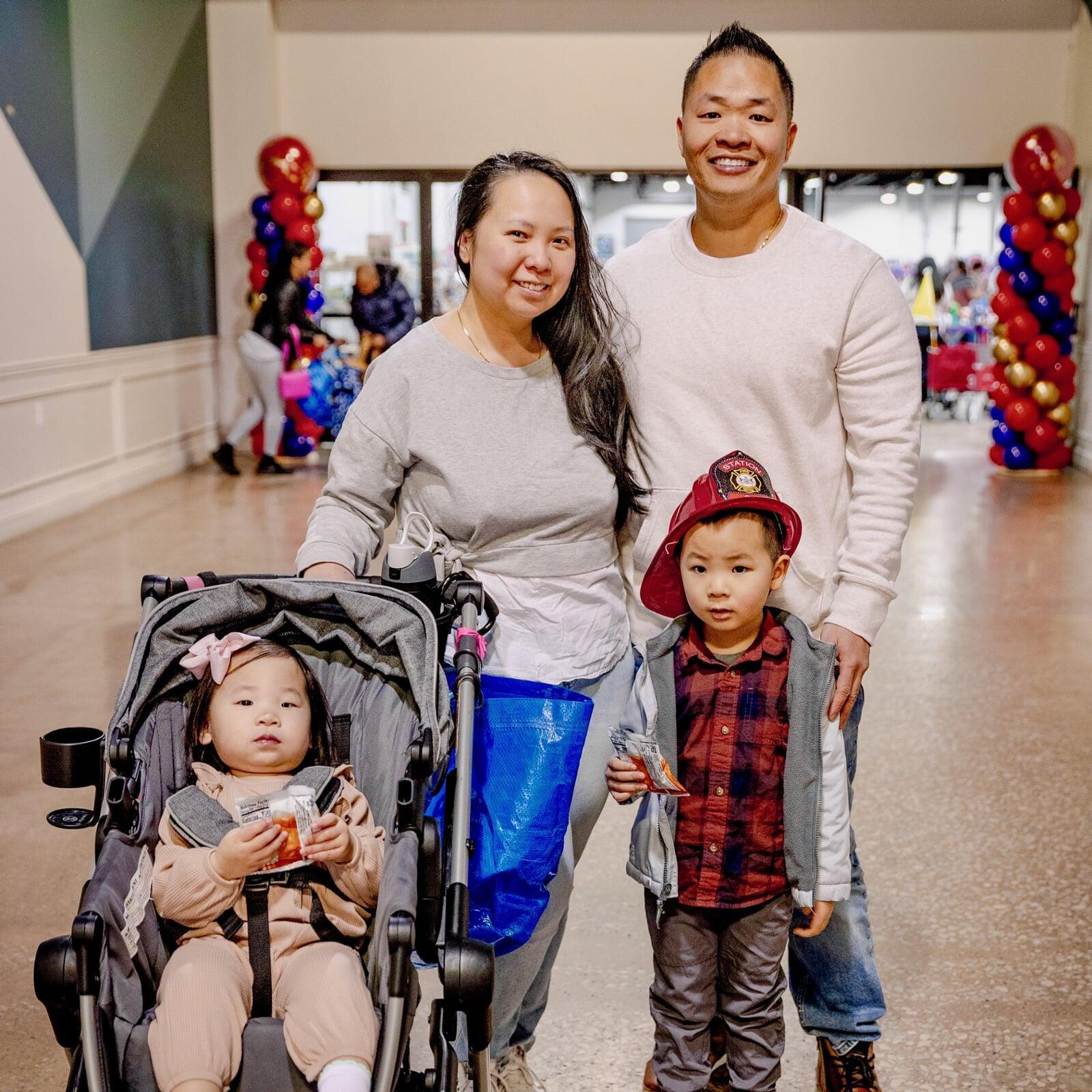 A couple and their two children pause for a photo prior to going inside to shop at the JBF sale in Oaks